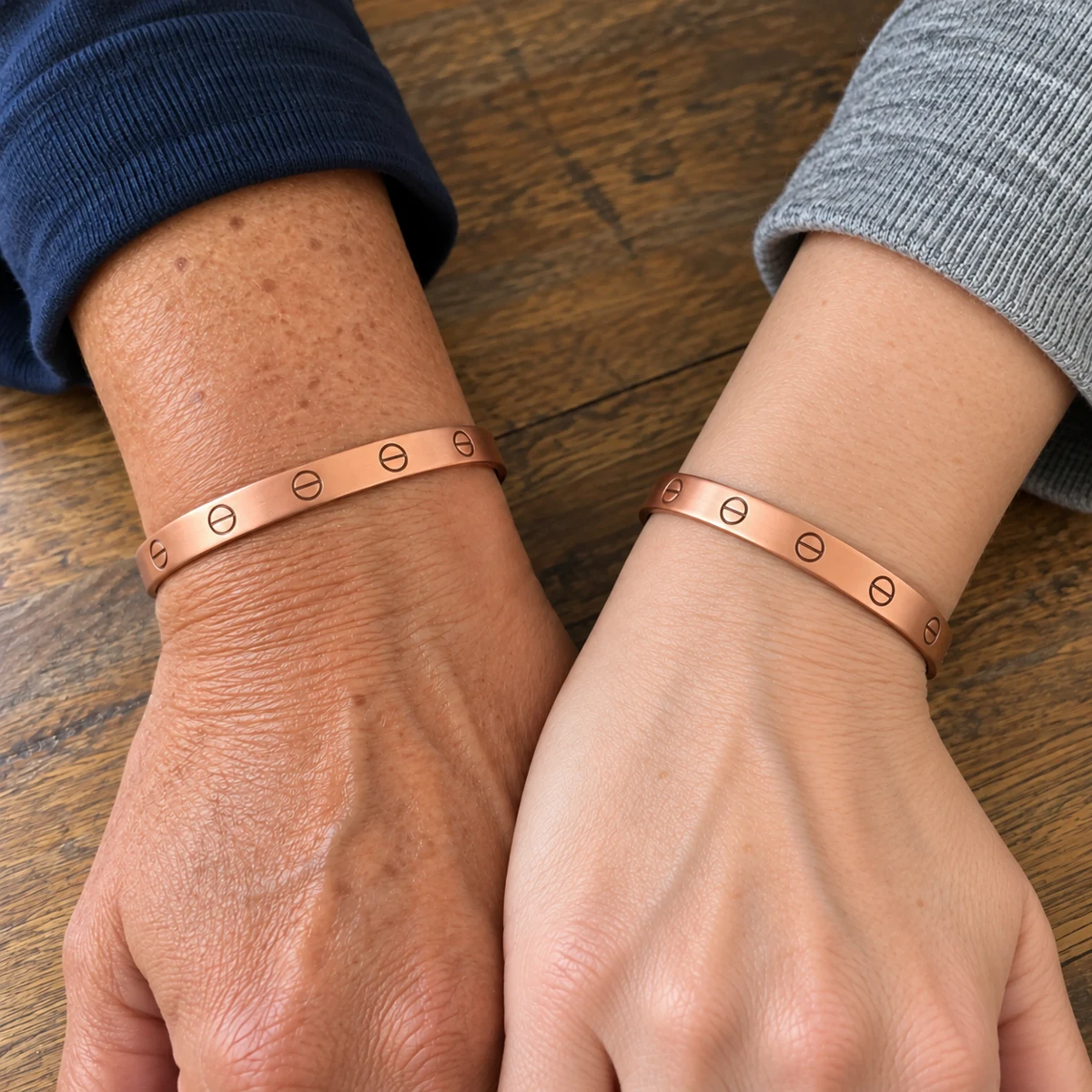 Two wrists wearing matching copper friendship bracelets